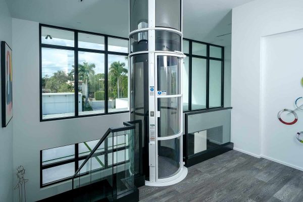 Modern home with glass elevator and large windows