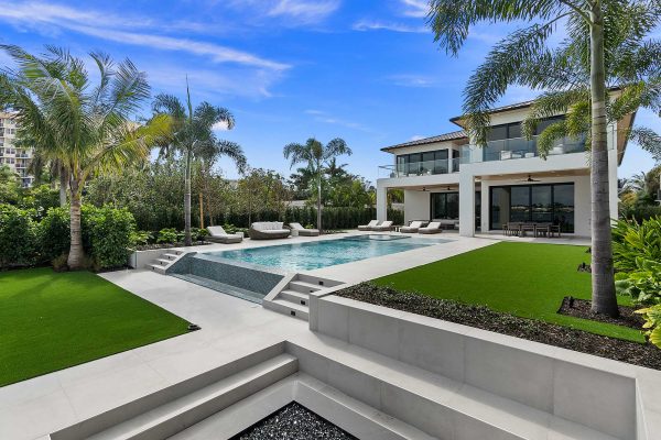 Luxury modern house with pool and palm trees.
