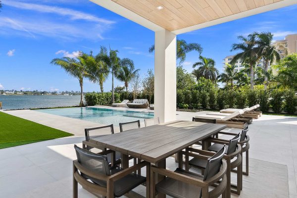 Luxury patio with pool and palm trees view.