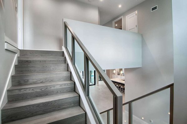Modern staircase interior with glass railing.