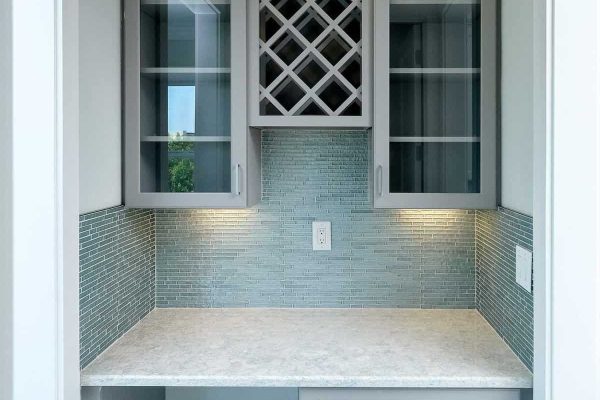 Modern small kitchen with cabinets and tile backsplash.