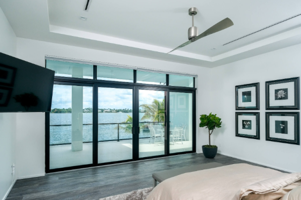 Modern bedroom with lake view and balcony access.