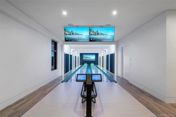 Luxury home bowling alley with screens.