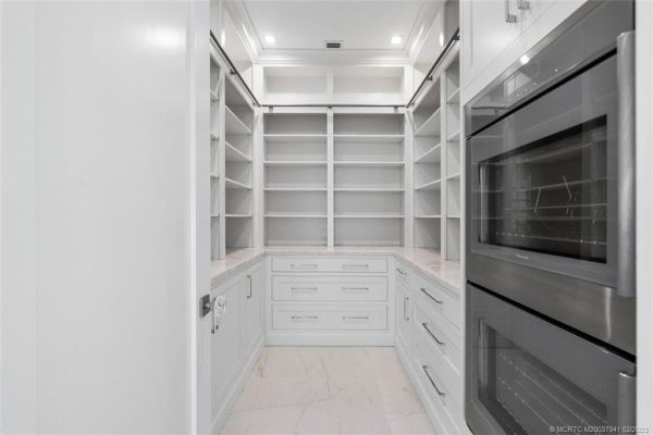 Spacious walk-in pantry with shelves and drawers.