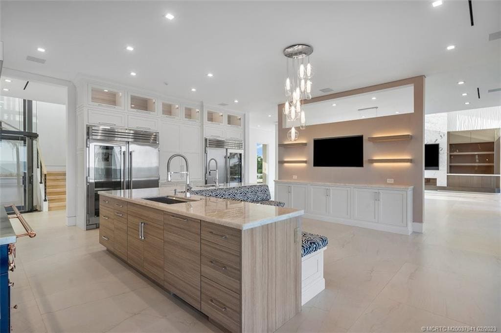 wKlOnyiFLXxYRP3T1FOv4tAopJPaWsFly8wMsk15N8U Modern kitchen with island and pendant lights.