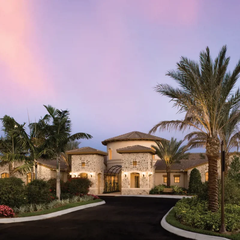 Elegant villa with palm trees at sunset.