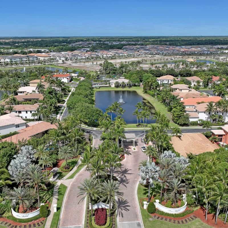 Aerial view of tropical residential neighborhood with water feature.