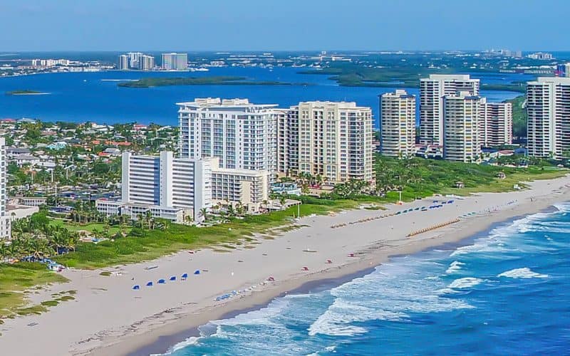 Aerial view of beachfront city with skyscrapers.