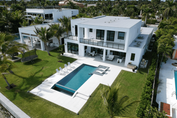 Modern white villa with pool and garden view.