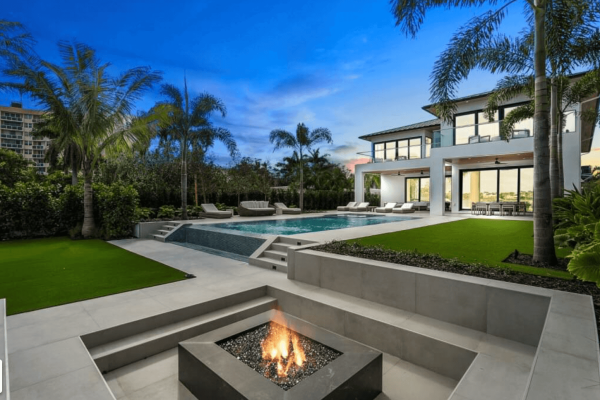 Luxury home with pool and fire pit at sunset